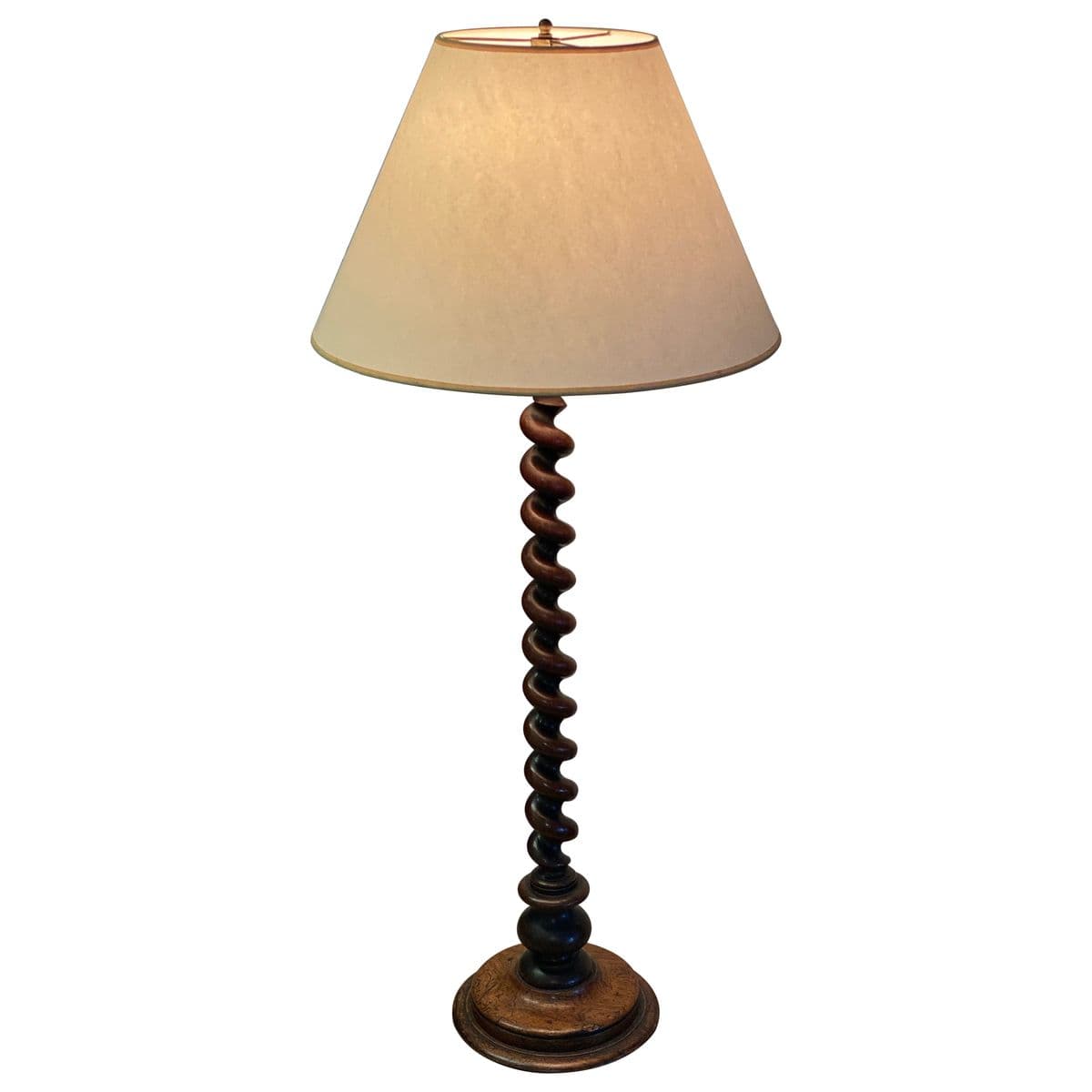 A traditional wooden floor lamp featuring a distinctive barley twist column. The lamp has a round, tiered base and is topped with a conical, light-colored fabric shade. The wood appears to be dark-stained, contributing to its classic aesthetic. — 3D model