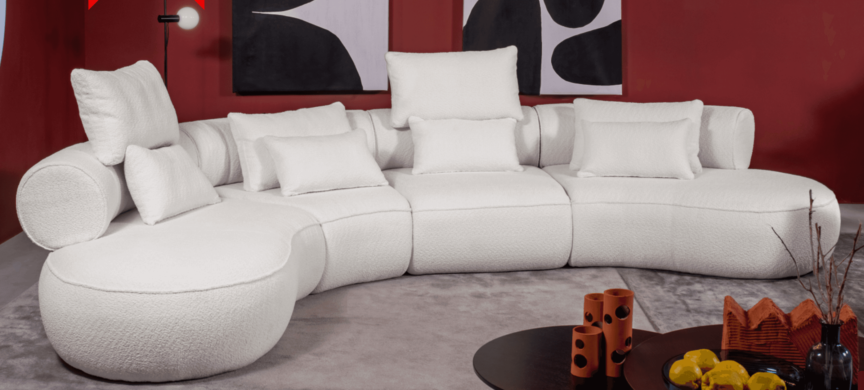 A large, modular, curved sectional sofa with a rounded chaise. The sofa is upholstered in a textured white fabric and features multiple loose back and throw pillows. The design is contemporary and appears to be a low-profile model. — 3D model