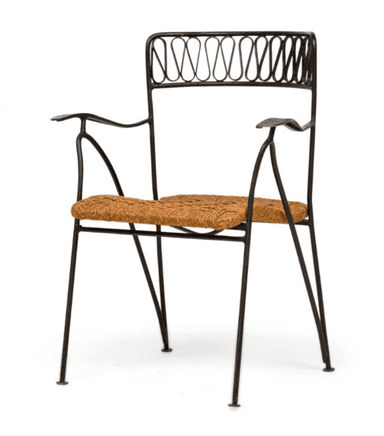 An armchair featuring a black wrought iron frame with slender legs and curved armrests. The backrest is adorned with an intricate, repeating scrolled pattern. The seat is constructed from tightly woven natural rush material, providing a textural contrast to the metal frame. The design evokes a classic bistro or Mediterranean aesthetic. — 3D model