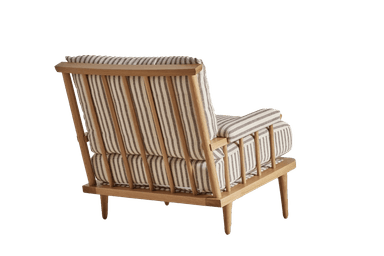 A contemporary armchair with a wooden frame and upholstered cushions. The frame features a spindle-back design and tapered legs. The seat and back cushions are generously padded, and the armrests are integrated into the frame with a slatted design. — 3D model