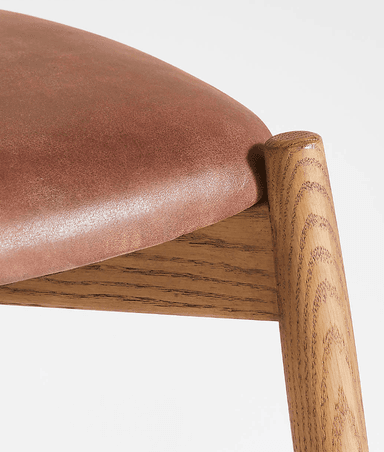 A modern dining chair constructed from light-toned oak wood with a brown leather upholstered seat. The chair features a minimalist design with tapered legs, a subtly curved backrest, and a sturdy wooden frame. — 3D model