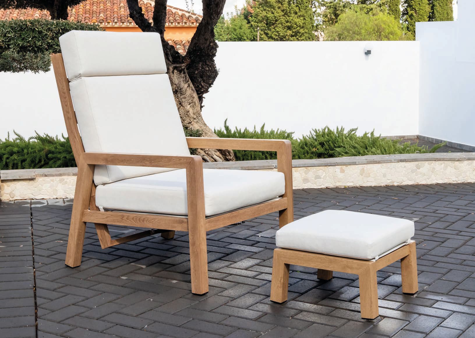 A wooden armchair with a high back and thick white cushions, accompanied by a matching wooden ottoman with a white cushion. The armchair features a slatted seat and back support, and its frame is constructed from solid wood with a natural finish. The design appears modern and suitable for outdoor use. — 3D model