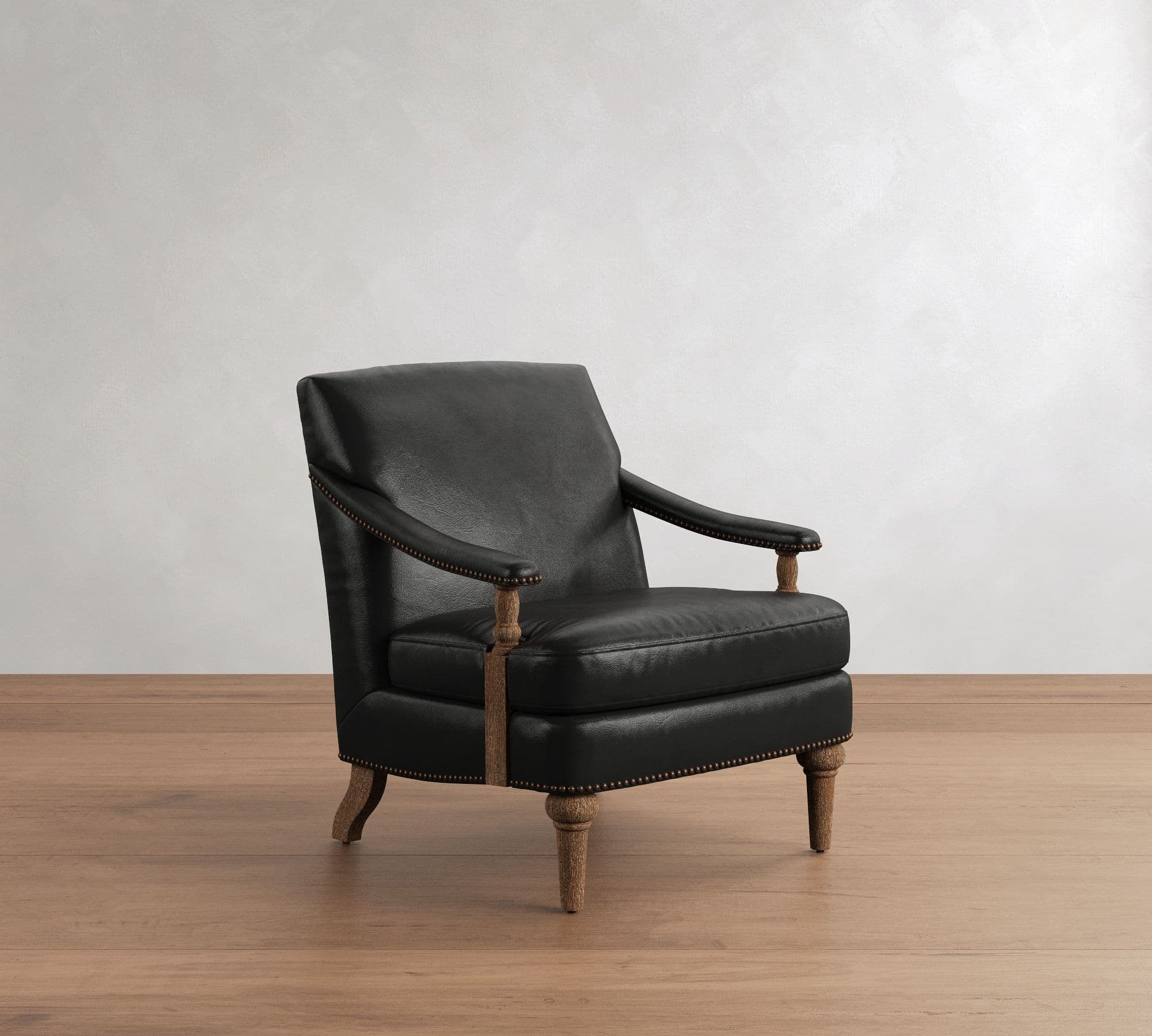 A traditional style armchair upholstered in black leather, featuring prominent brass nailhead trim along the armrests and base. The chair is supported by turned wooden legs and has exposed wooden arm supports, contributing to its classic aesthetic. — 3D model