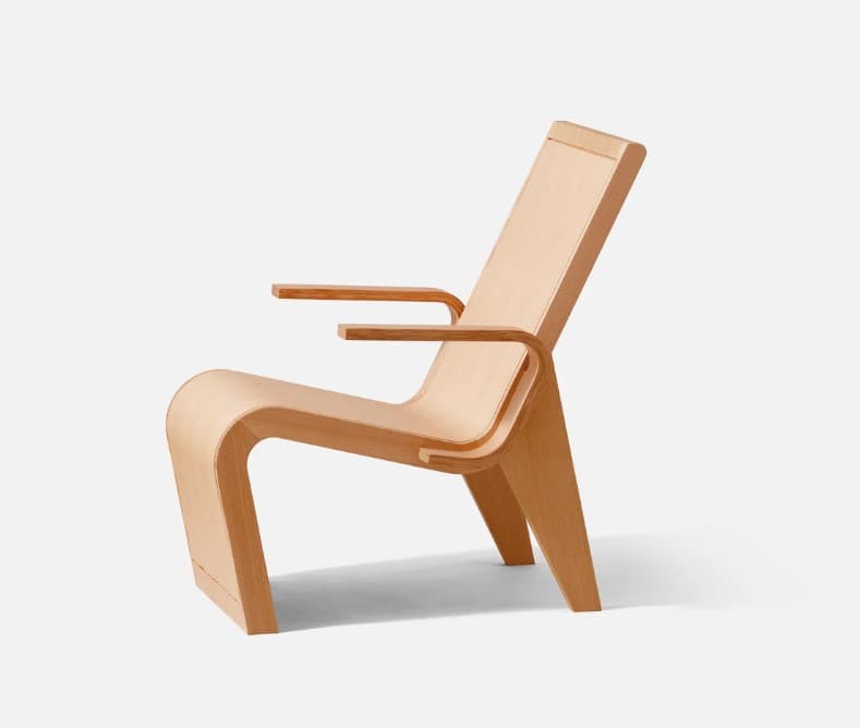 A modernist bent plywood lounge chair with a natural, light wood finish, featuring a reclined backrest and integrated armrests. The chair showcases a continuous, organic form crafted from laminated wood sheets. — 3D model