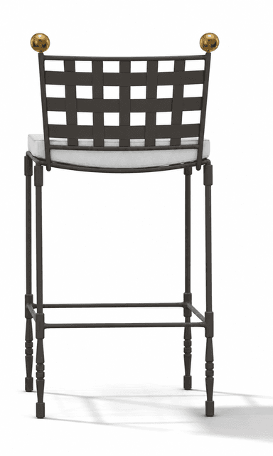 A tall bar stool featuring a dark wrought iron frame with a distinctive woven grid backrest and two spherical brass finials. The seat is cushioned and upholstered in a light-colored fabric, likely off-white or cream. The legs are slender, with some turned details towards the bottom, and include a square footrest for support. — 3D model