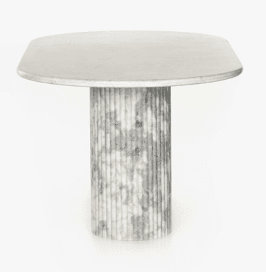 A contemporary dining table featuring an oval white marble tabletop supported by a substantial fluted pedestal base made of grey and white veined marble. The base has a rounded, pill-like shape, complementing the oval top. — 3D model