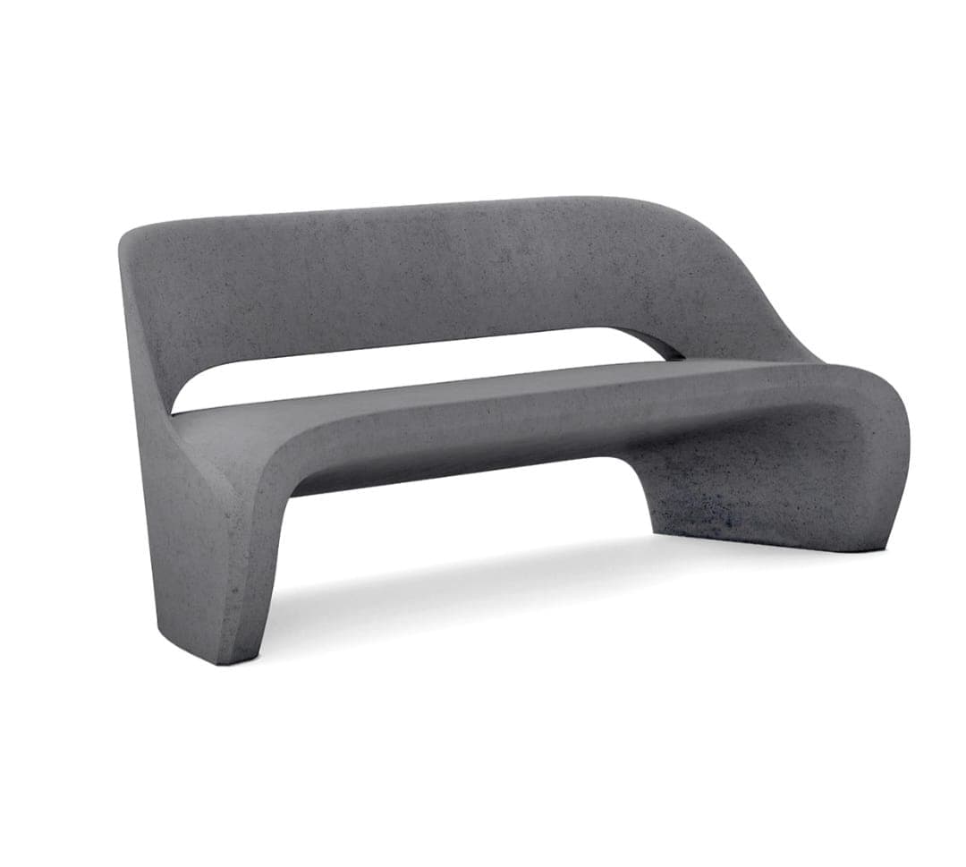 A modern, dark gray, monolithic bench made of concrete, featuring a continuous, curved form that integrates the backrest, seat, and base. It has an open-back design with a distinct gap between the seat and back, contributing to its sculptural aesthetic. — 3D model