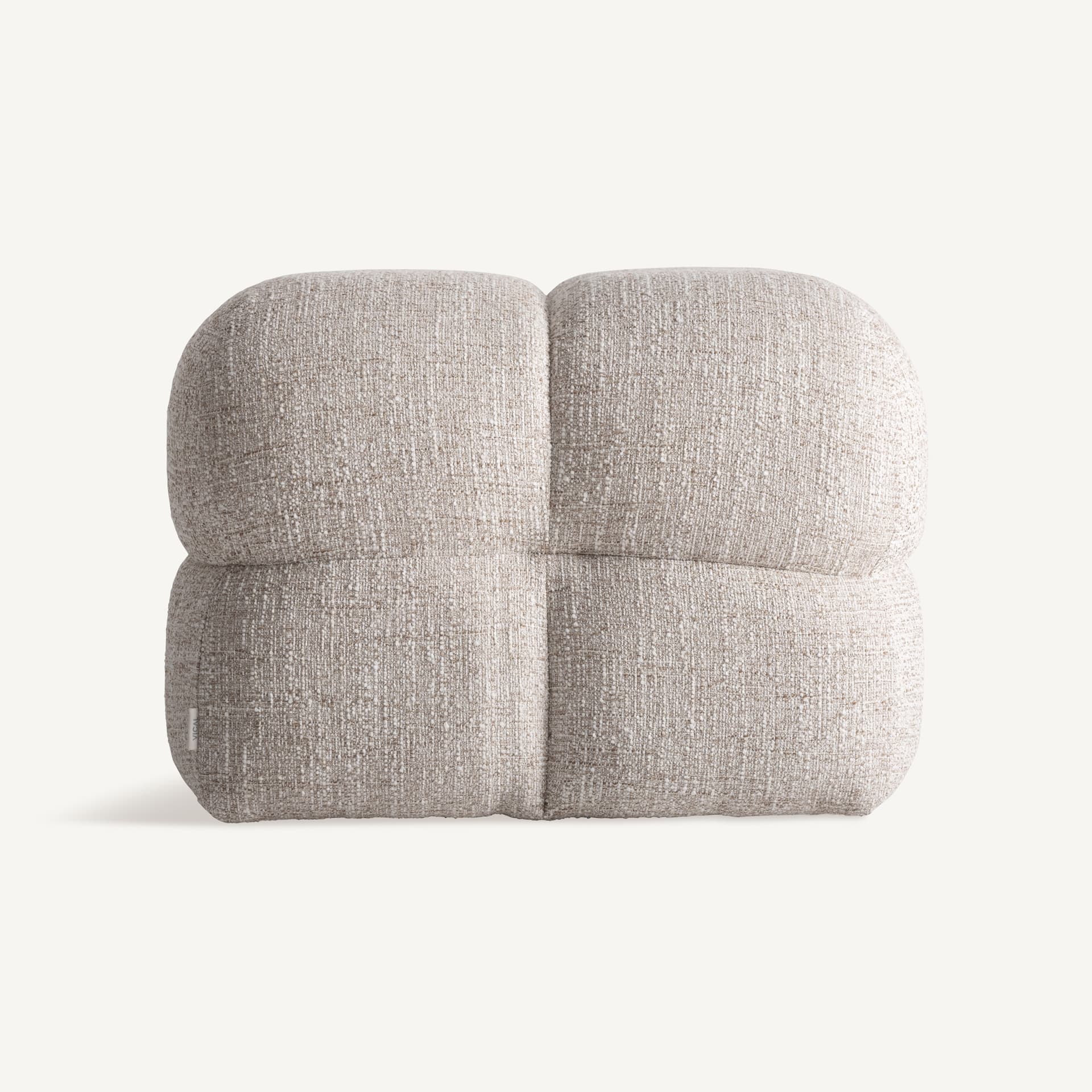 A low, upholstered ottoman with rounded edges, divided into four cushioned sections by stitched seams. The upholstery has a textured appearance with a mix of light and dark fibers, giving it a speckled effect. A small white tag with 'VICAI' is visible on the lower left side. — 3D model