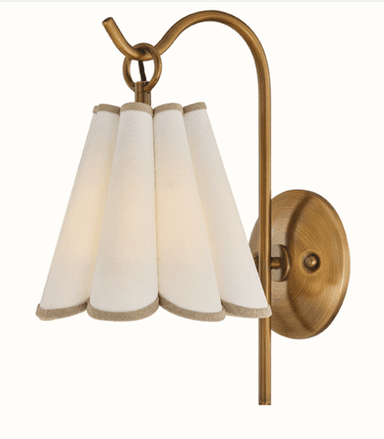 A wall-mounted light fixture featuring an antique brass finish and a distinctive pleated, fluted fabric shade. The shade is off-white or cream-colored, with a subtle trim along the bottom edge. The brass arm extends from a round backplate, curving elegantly to hold the shade. — 3D model