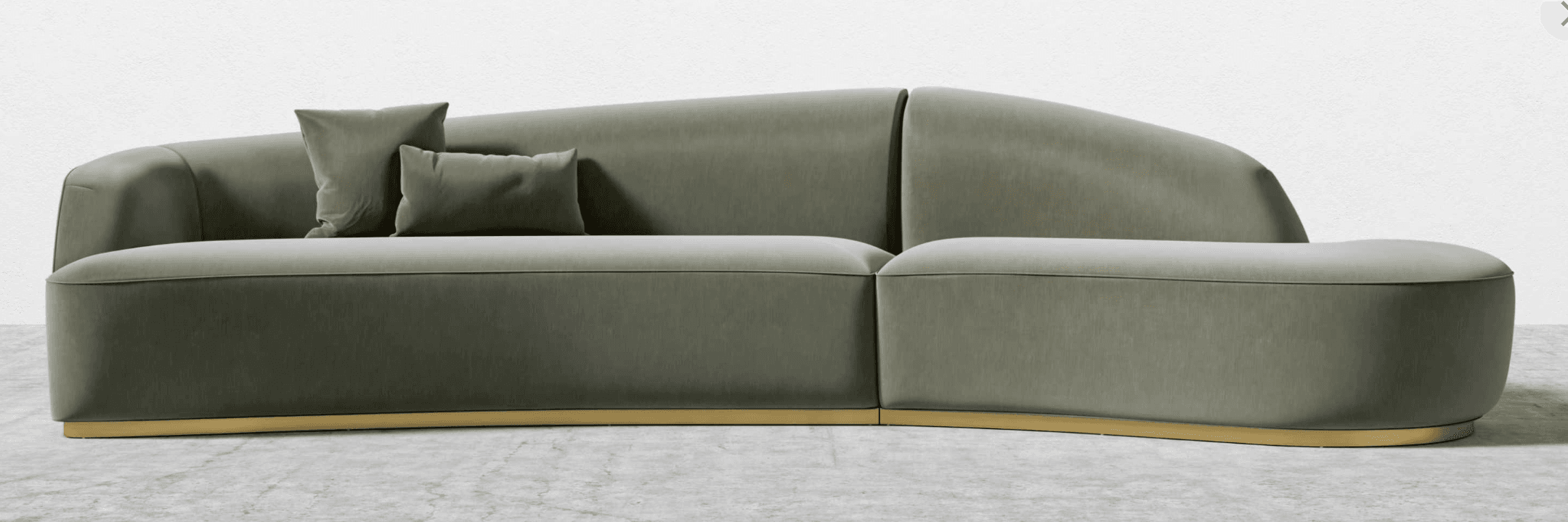A contemporary, modular sofa with curved lines and a low profile. The sofa features upholstered cushions in a soft, muted green fabric and is supported by a thin, polished brass base. It includes two decorative throw pillows. — 3D model