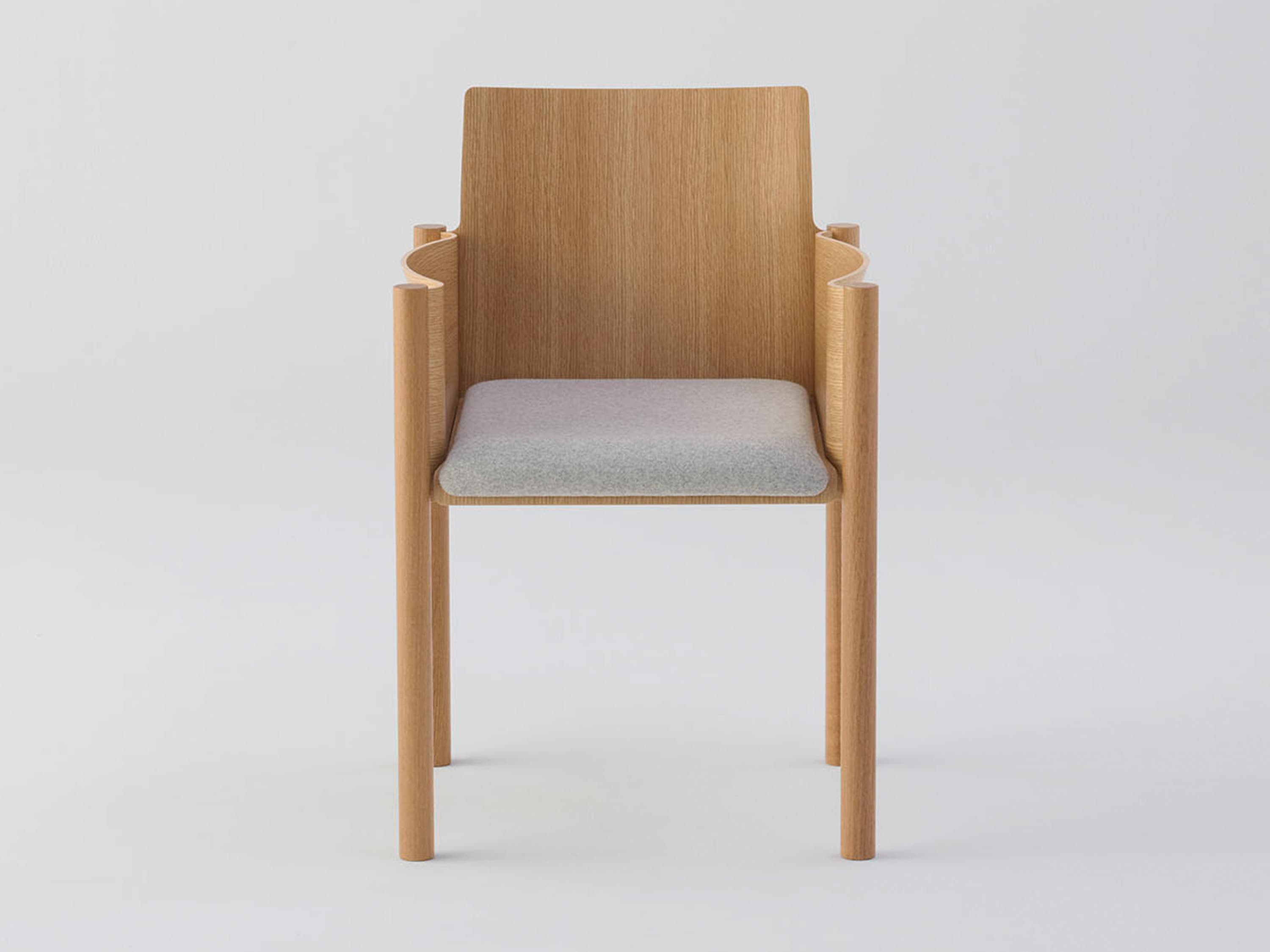 A contemporary armchair crafted from light-toned wood, featuring a flat wooden backrest, distinctive curved armrests made of multiple rounded sections, and a padded light grey fabric seat. The legs are simple cylindrical wooden dowels. — 3D model