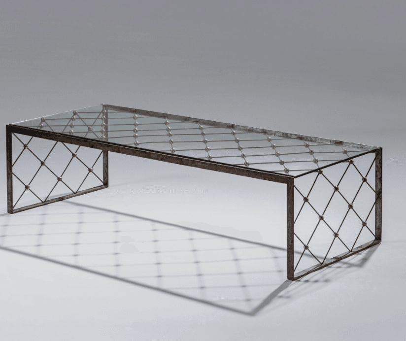 A rectangular coffee table with a glass top and a metal base. The base features a crisscross pattern of thin metal rods with spherical brass accents at each intersection. The legs are simple, straight forms that support the rectangular frame. — 3D model