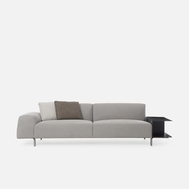 A modern two-seater sofa upholstered in light grey fabric, featuring a minimalist design with slim metal legs and an integrated black rectangular side table with open shelving on one end. — 3D model