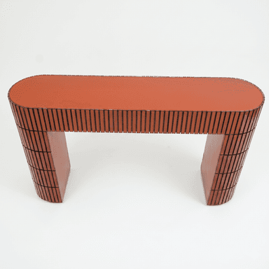 A console table with an organically curved top and a U-shaped base. The piece features a textured surface on the exterior of the base and the edges of the top, constructed from vertically aligned rectangular elements. The main body of the top and the interior of the base are finished in a solid, glossy reddish-brown color. — 3D model