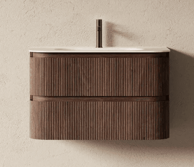 A wall-mounted bathroom vanity with a white countertop and integrated sink. The vanity features two drawers with fluted wooden fronts, and a dark metal faucet. The overall design is modern and minimalist, with a focus on texture and natural materials. — 3D model