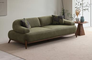 An olive green upholstered two-seater sofa featuring a clean, contemporary design with rounded arms and a continuous backrest. It stands on a dark wooden frame with slender, tapered wooden legs and includes two patterned throw pillows. — 3D model