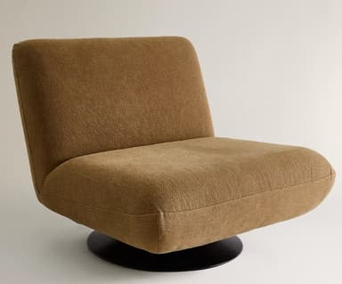 A modern armchair with a low profile and a distinctive upholstered shell. It features a single pedestal base, likely for swivel functionality. The upholstery appears to be a textured fabric with a woven appearance. The design emphasizes rounded forms and a comfortable, enveloping silhouette. — 3D model