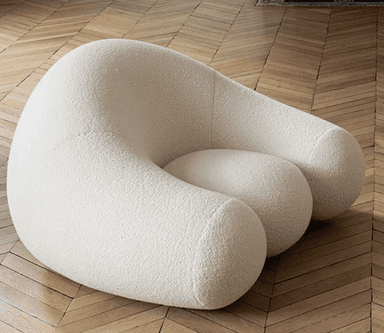 A light grey, upholstered, organically shaped piece of furniture, resembling a large smooth pebble or rock. Its surface appears to be a soft, textured fabric. — 3D model