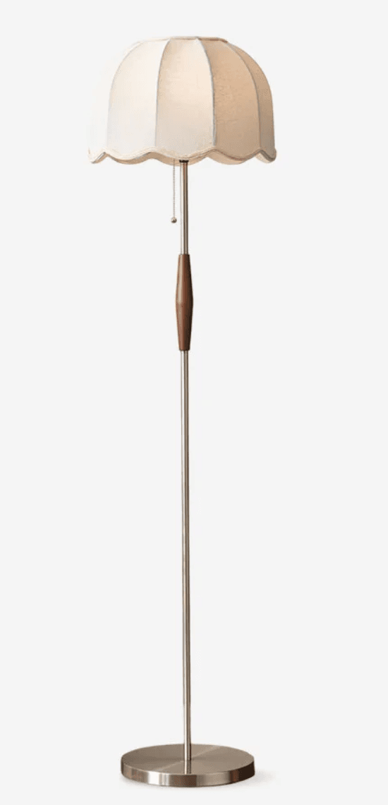 A tall, slender floor lamp featuring a brushed metal base and stem, accented with a cylindrical wooden element, and topped with a bell-shaped, scalloped white fabric shade. — 3D model