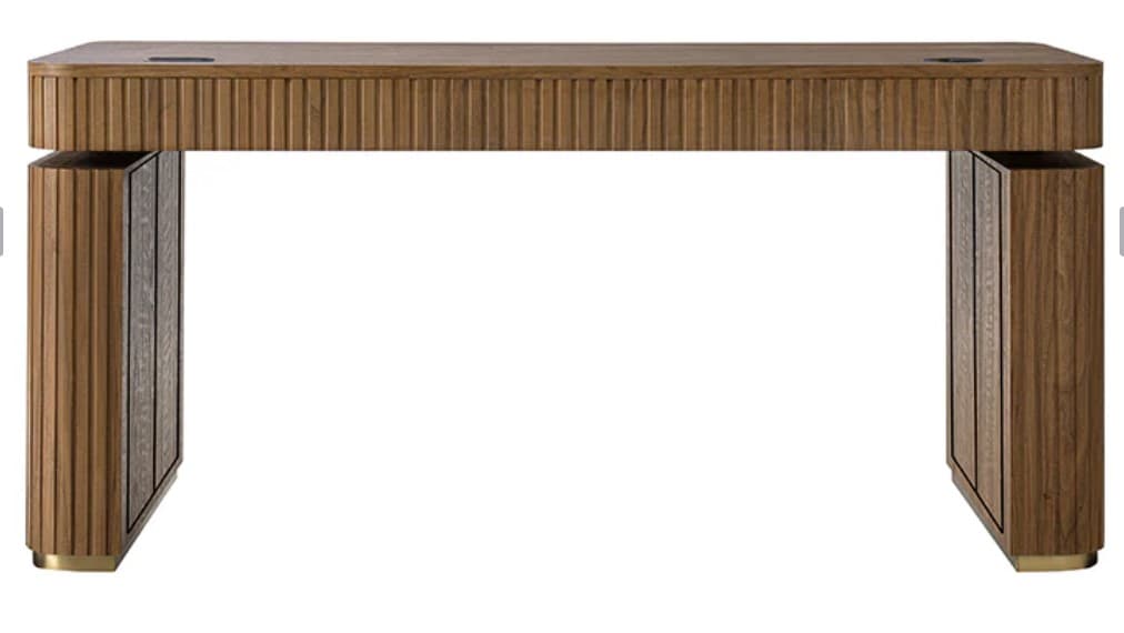 A contemporary wooden desk with a distinct ribbed texture on the front edge of the tabletop and the sides of the legs. The desk features a solid rectangular top and two substantial leg structures. The legs have vertical ribbed wooden panels on their outer sides, with inset decorative panels that appear to be a different material or finish, possibly a textured metal or stone. A thin metallic accent piece is visible at the base of each leg. The overall design suggests a modern, possibly executive-style desk. — 3D model