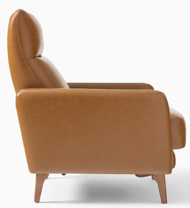 A modern armchair upholstered in a smooth, caramel-colored leather. It features a high backrest with a separate headrest cushion, padded armrests, and a thick seat cushion. The chair is supported by four tapered wooden legs. The overall design suggests a comfortable and stylish piece for a living space. — 3D model