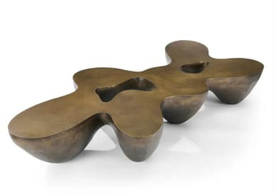 A low-profile, sculptural coffee table with an organic, undulating form and a patinated bronze finish. It features integrated depressions on its surface. — 3D model