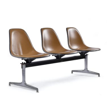 A three-seater bench with individual molded seats attached to a central metal frame. Each seat has a contoured ergonomic design and is upholstered in a tan material. The frame and legs appear to be made of dark metal, possibly cast aluminum or steel, with a stylized 'X' or pedestal base for each seat's support. — 3D model
