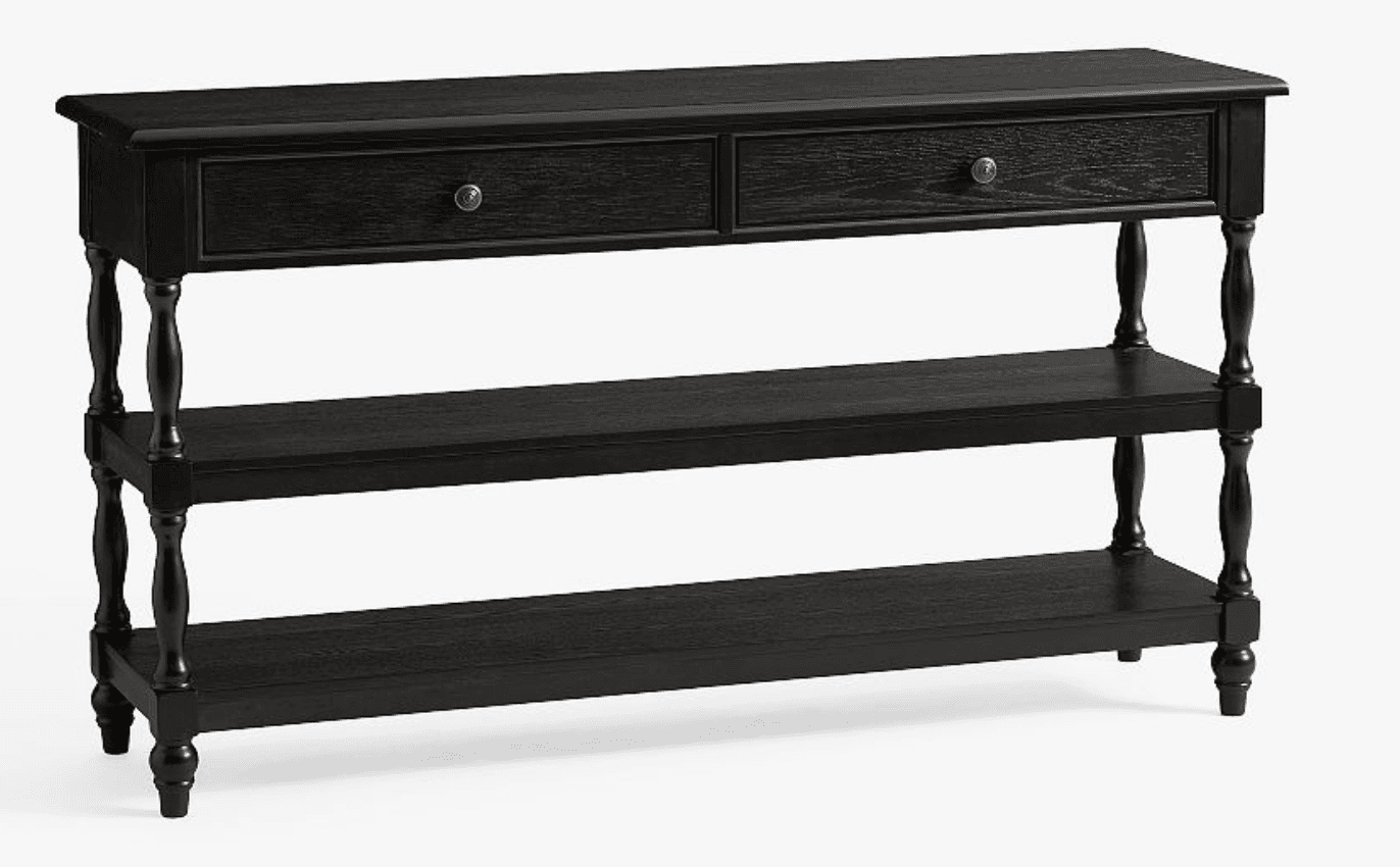 A black console table featuring a rectangular top with a beveled edge. It has two drawers across the front, each with a brass-toned knob. The table is supported by four turned legs and includes two open shelves situated below the drawers, running the full length of the table. — 3D model