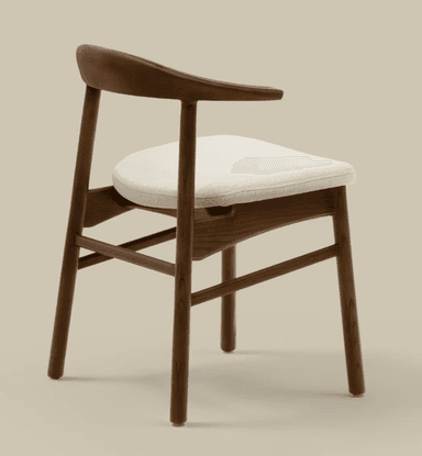 A modern dining armchair featuring a solid dark wood frame and a padded, light-colored fabric seat. The backrest is gently curved and seamlessly integrates with the armrests. The chair stands on four tapered wooden legs connected by horizontal stretchers for stability. — 3D model
