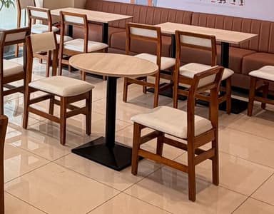 An oval-shaped table featuring a light wood or laminate top and a black metal pedestal base. The base consists of a cylindrical column rising from a square, tapered foundation. — 3D model