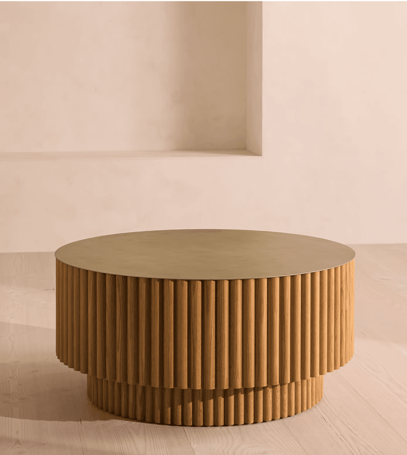 A cylindrical coffee table with a fluted wooden base and a metallic top. The base is composed of numerous vertical wooden slats, creating a textured, ribbed effect. It features a distinct tiered design, with the upper section being wider than the lower support. The tabletop appears to be made of a brushed metallic material, possibly brass or a similar alloy, with a matte finish. — 3D model