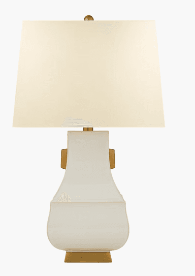 A decorative table lamp with a square, off-white lampshade and a ceramic base. The base has a distinctive curved silhouette, widening at the bottom and tapering towards the top, with a glossy finish. It features a metallic accent on the side. The base is supported by a rectangular metallic base. — 3D model