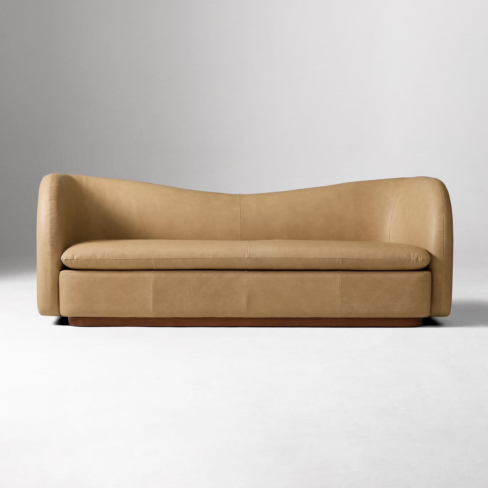 A contemporary two-seater loveseat upholstered in tan leather with a curved back and integrated armrests, resting on a dark wooden plinth base. — 3D model