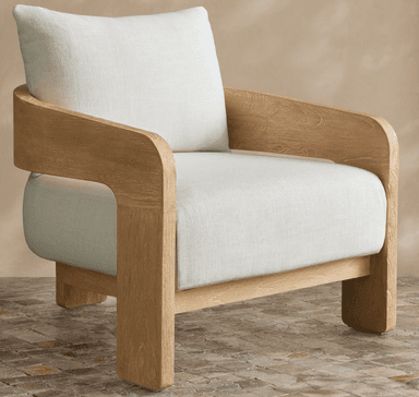 A modern upholstered armchair featuring a light-toned wooden frame and thick, cream-colored fabric cushions. The frame exhibits a prominent natural wood grain texture and gently curved armrests. — 3D model
