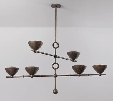 A six-light chandelier featuring a linear, branching design with a distressed bronze finish. The fixture hangs from a ceiling canopy via a single downrod. Its central vertical stem branches into two horizontal arms, with the upper arm supporting two light sources and the lower, longer arm supporting four. Each light source is housed within a small, bowl-shaped shade, pointing upwards. Circular accents are integrated into the central stem where the arms attach. The metal surface has a textured, aged appearance. — 3D model