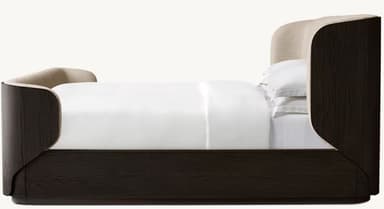 A modern platform bed featuring a dark wood frame with distinct graining and gently curved corners. The headboard is integrated, upholstered in a light, neutral fabric, and extends along the sides, enveloping the sleeping area. The bed has a low-profile base, suggesting a platform design that does not require a box spring. White bedding is present, indicating its function. — 3D model