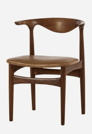 A Mid-Century Modern dining chair crafted from dark wood, featuring a distinctively sculpted backrest that seamlessly transitions into a single, extended armrest. The seat is upholstered in a light tan leather or faux leather, showing some signs of wear. The chair stands on four tapered legs, consistent with Scandinavian design principles. — 3D model