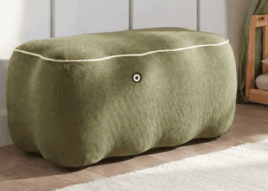 A contemporary rectangular ottoman upholstered in a textured olive green knitted fabric. It features soft, rounded edges and a light-colored contrast piping along the top perimeter. The base of the ottoman has a subtle wavy profile and rests on small, discreet dark feet. — 3D model