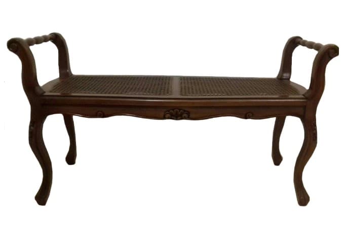 A classic French Provincial style bench featuring a dark stained wooden frame with intricate carvings and cabriole legs. The seat is constructed from two panels of woven cane, offering a breathable and textural surface. It includes gracefully curved armrests with carved details, enhancing its traditional aesthetic. The overall design suggests elegance and craftsmanship typical of 18th-century European furniture. — 3D model