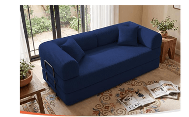 A dark navy blue convertible sofa bed, upholstered in a distinct ribbed fabric texture. The design features a low profile, with the main body appearing to be a stack of cushions that can unfold into a bed. It includes two rounded bolster pillows serving as armrests and two square accent pillows. A black metal folding mechanism with small wheels is visible at one end, indicating its convertible functionality. — 3D model
