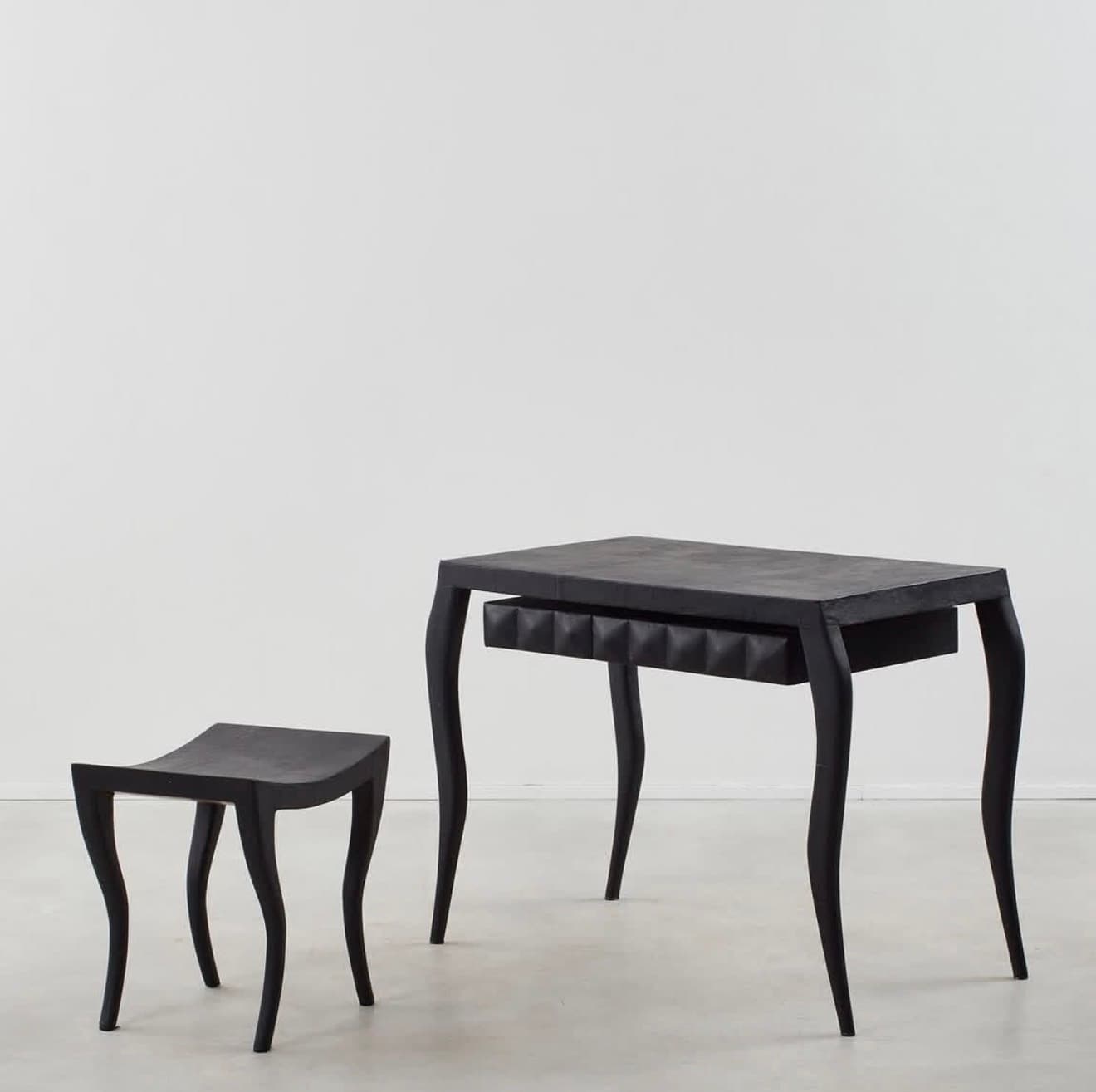 A black console table featuring a rectangular top, four curved cabriole legs, and a single drawer. The drawer front has a distinctive textured, possibly pyramidal or studded, surface. The entire piece is finished in a matte black. — 3D model