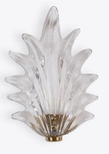 A decorative wall sconce featuring a clear, sculpted glass element resembling organic forms, possibly inspired by nature or flames. The glass is multi-faceted, creating reflections and refractions of light. It is mounted on a metallic base with visible mounting points. — 3D model