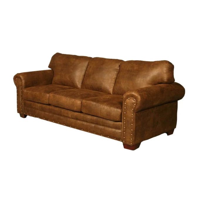 A robust three-seater sofa upholstered in a distressed brown leather or high-quality imitation, featuring classic rolled armrests. The arms and the bottom front panel are adorned with prominent brass or bronze nailhead trim, enhancing its traditional and rustic aesthetic. It has three individual seat cushions and three separate back cushions, providing defined seating. The sofa rests on short, dark, possibly wooden bun feet. — 3D model