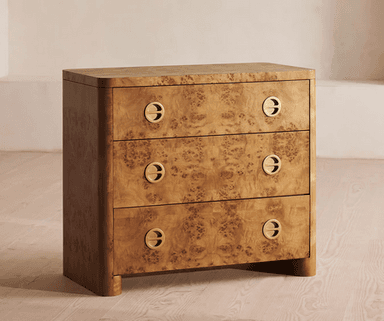 A three-drawer chest of drawers crafted with burl wood veneer, featuring rounded corners and edges, and circular recessed brass pull handles. The unit stands on integrated rounded feet. — 3D model