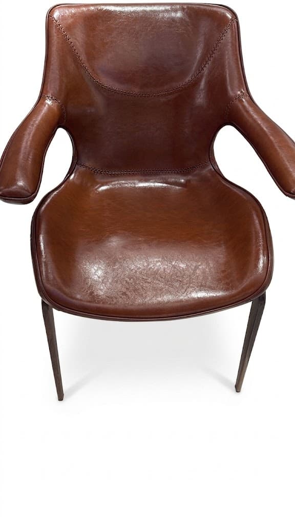 A brown leather armchair featuring a sculpted form with integrated armrests and exposed stitch detailing. The chair is supported by dark, slender, tapered legs. — 3D model