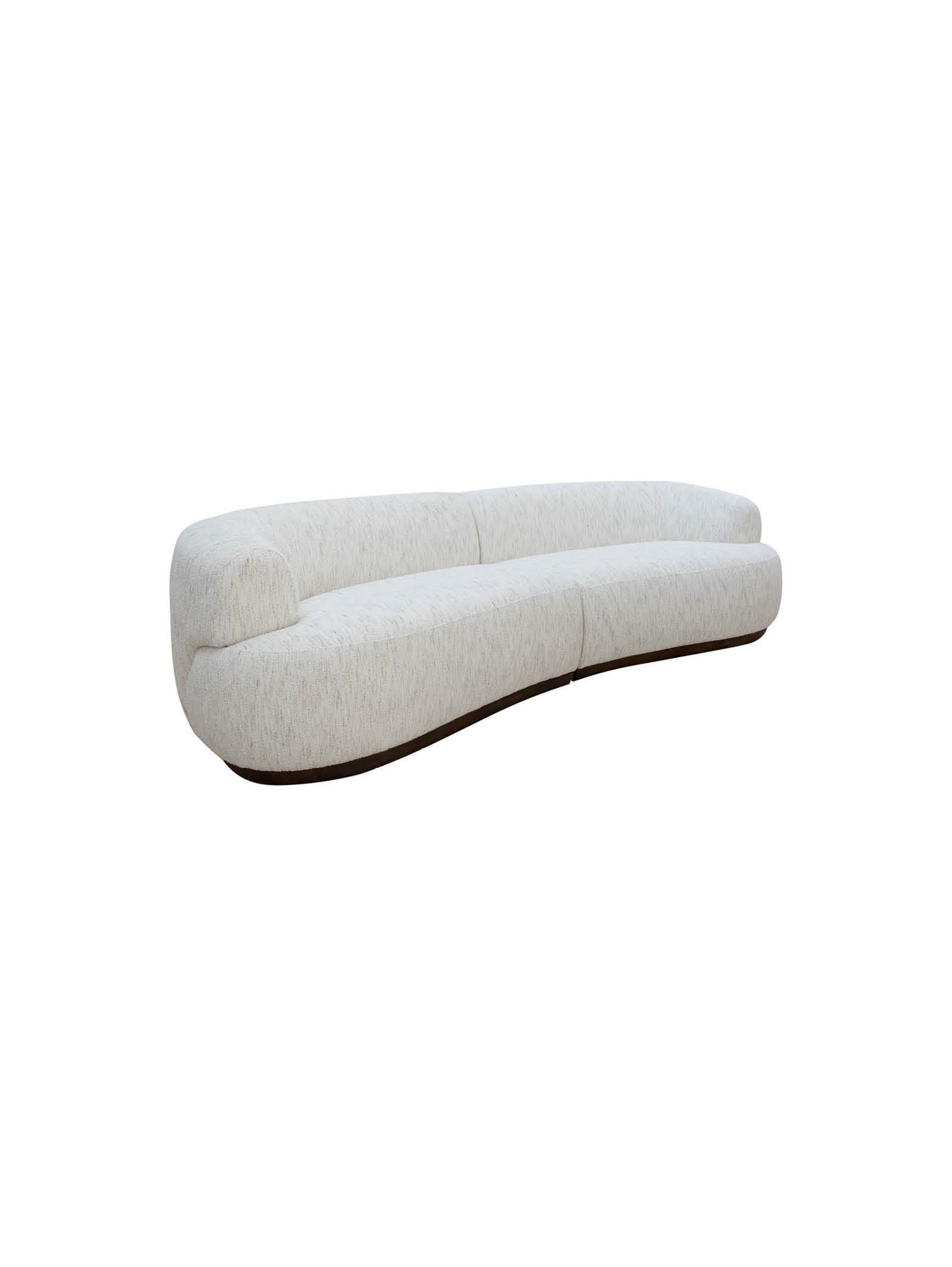 A curved sofa with a rounded armrest on the left side. The sofa features a plush, textured upholstery and a dark, possibly wood, base that follows the organic curve of the seating. — 3D model