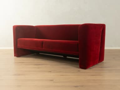 A two-seater sofa with a distinct geometric design. It features deep red velvet upholstery, high, angular armrests that extend downwards to form the base, and a single seat cushion. — 3D model