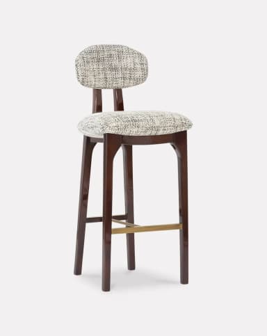 A high-backed bar stool featuring a dark stained wooden frame, a contoured upholstered seat, and a separate, floating upholstered backrest. The frame includes splayed legs and a brass footrest. The upholstery is a textured, patterned fabric in monochrome tones. — 3D model