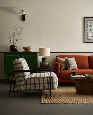 A modern lounge chair featuring plush plaid upholstery in neutral tones and a minimalist black metal frame with subtle brass accents. — 3D model