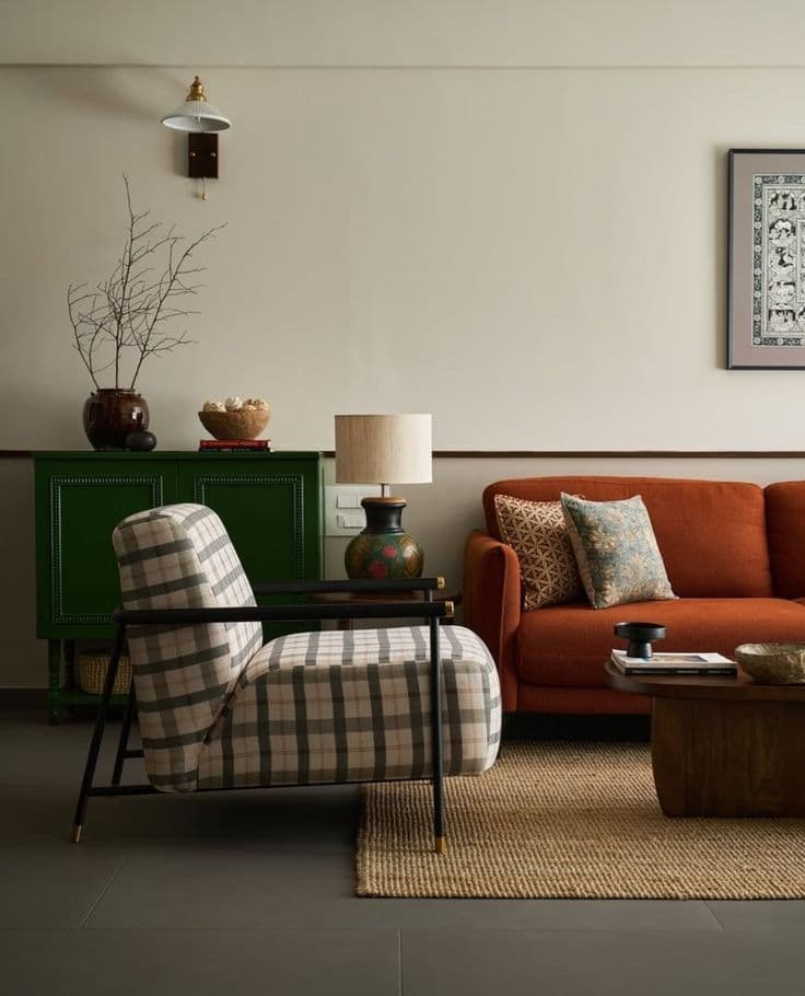 A modern lounge chair featuring plush plaid upholstery in neutral tones and a minimalist black metal frame with subtle brass accents. — 3D model